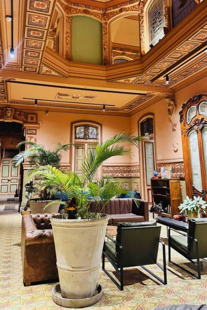 Elegantes Hotelinterieur mit Pflanzen und historischen Architekturdetails.